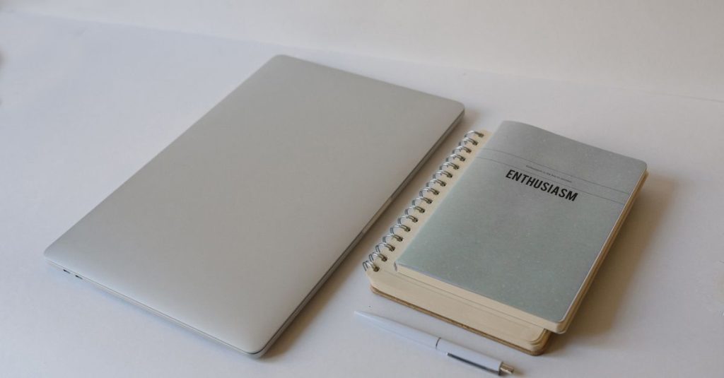 Laptop and notebooks on a desk for multi-department AI workflow planning